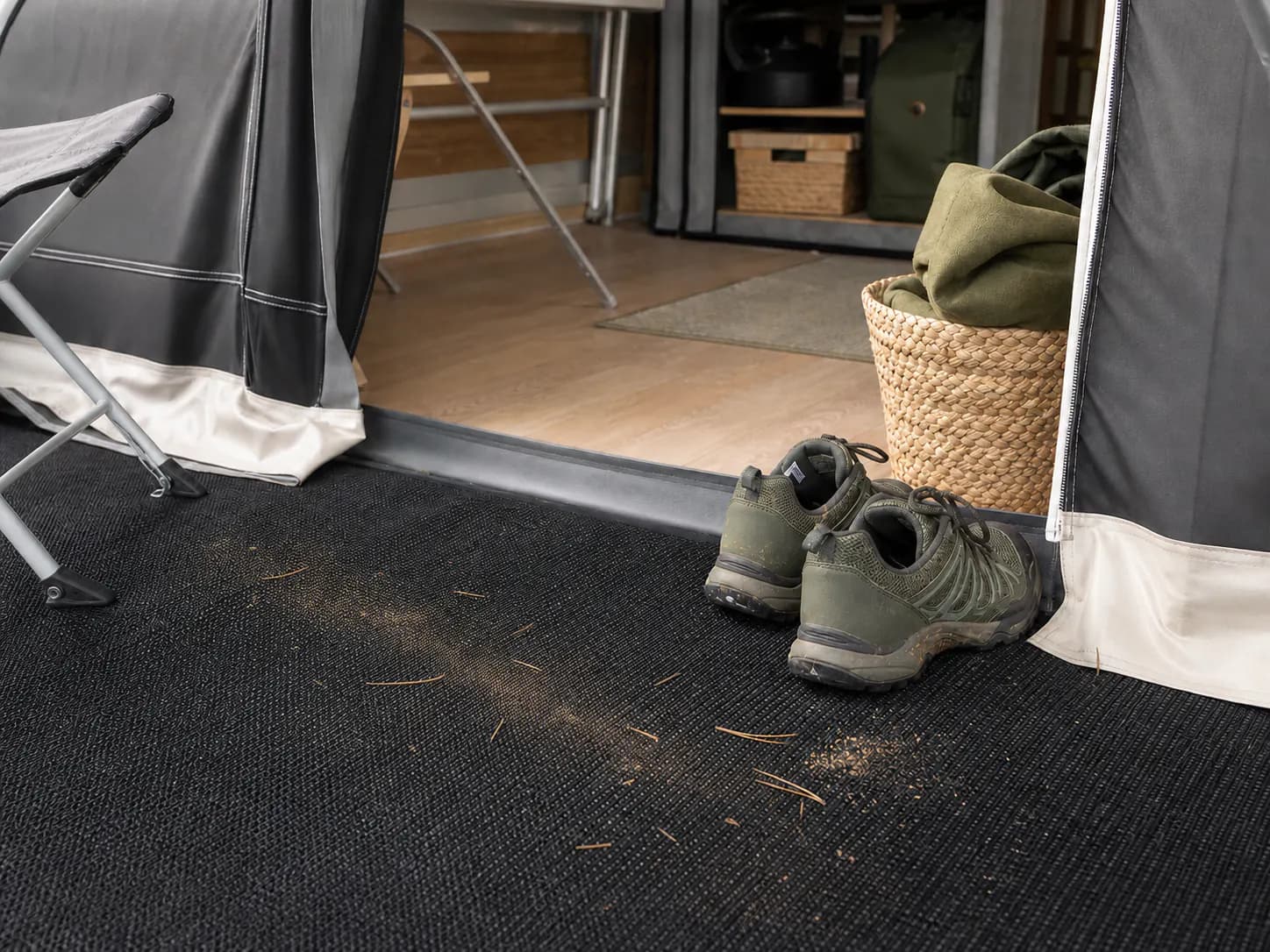 Tørt sand og små blade ved indgangen til et fortelt på camping